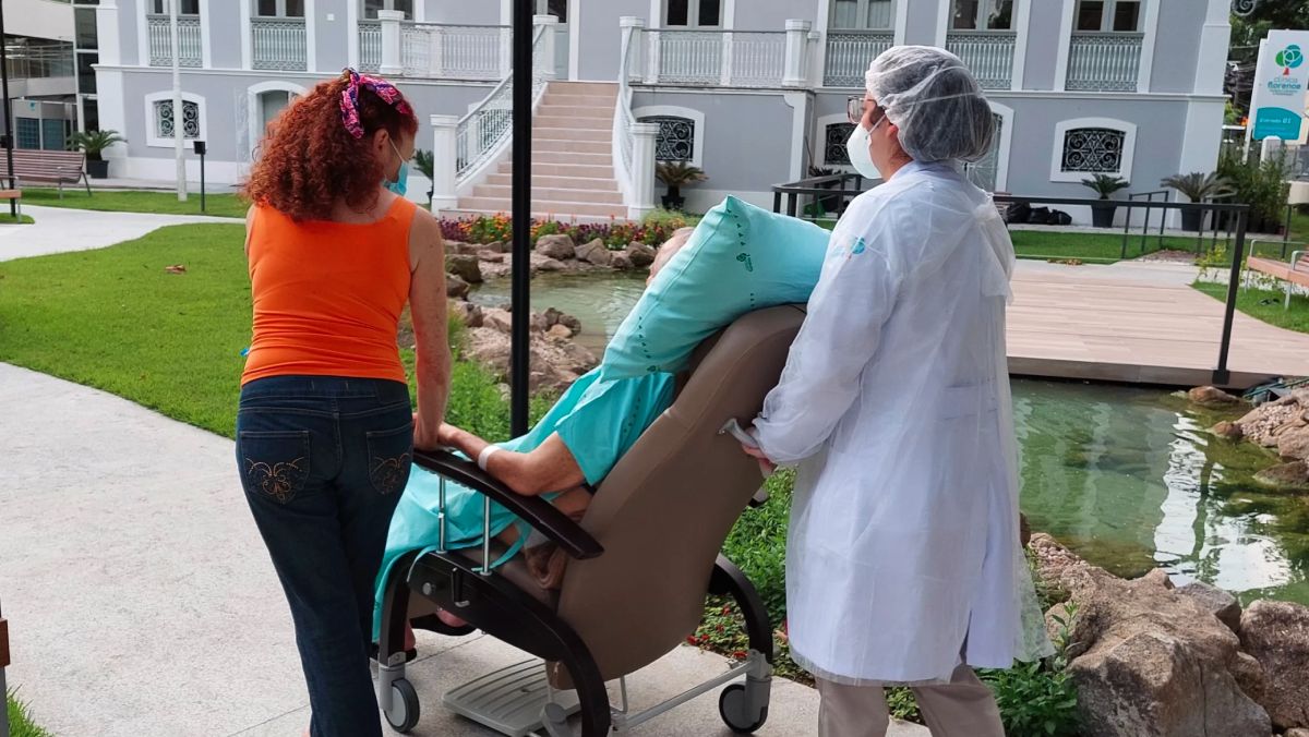 Profissional de reabilitação acompanhando paciente em terapia motora.