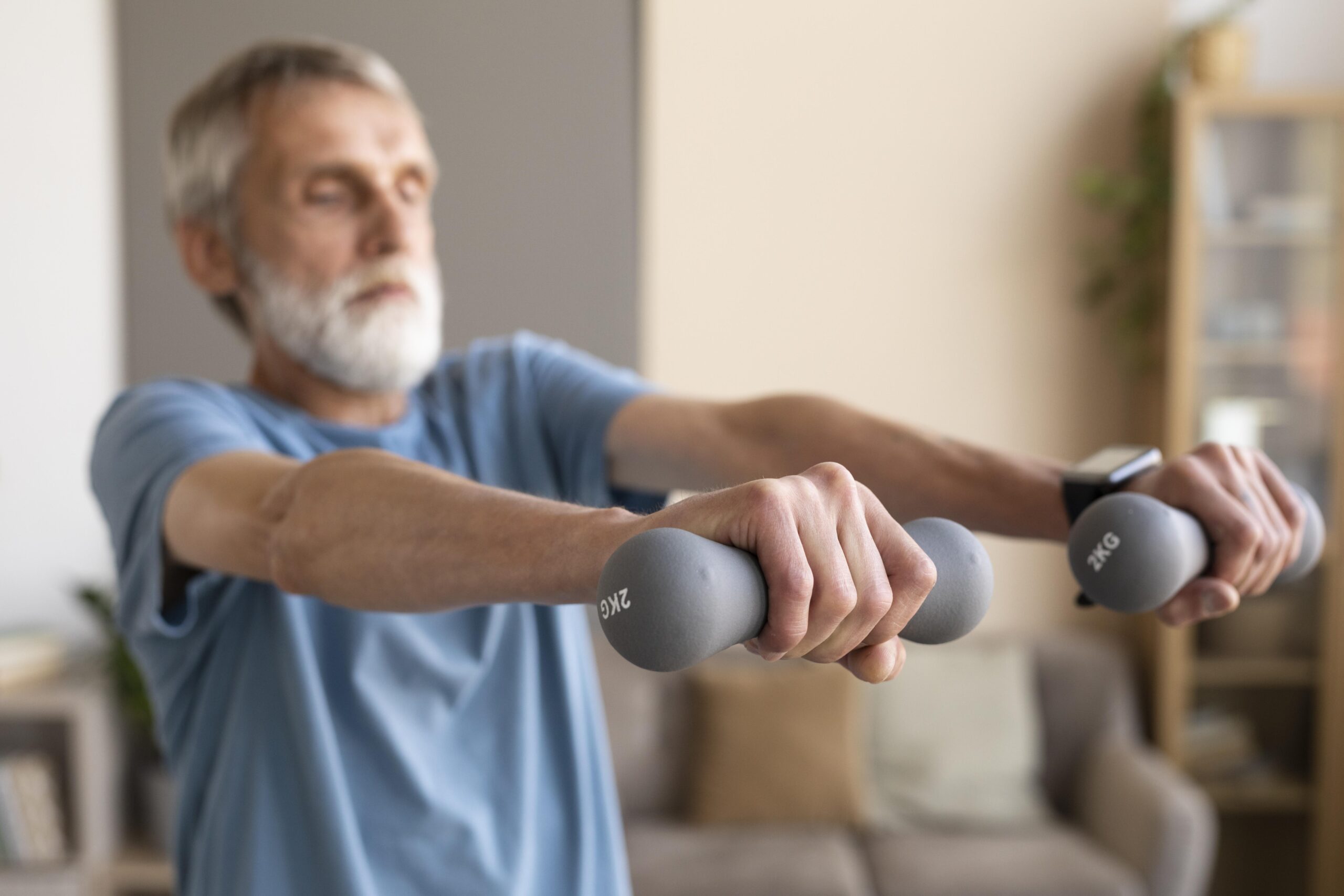 Homem idoso realizando exercícios físicos com halteres leves em casa, como parte do tratamento e prevenção da sarcopenia