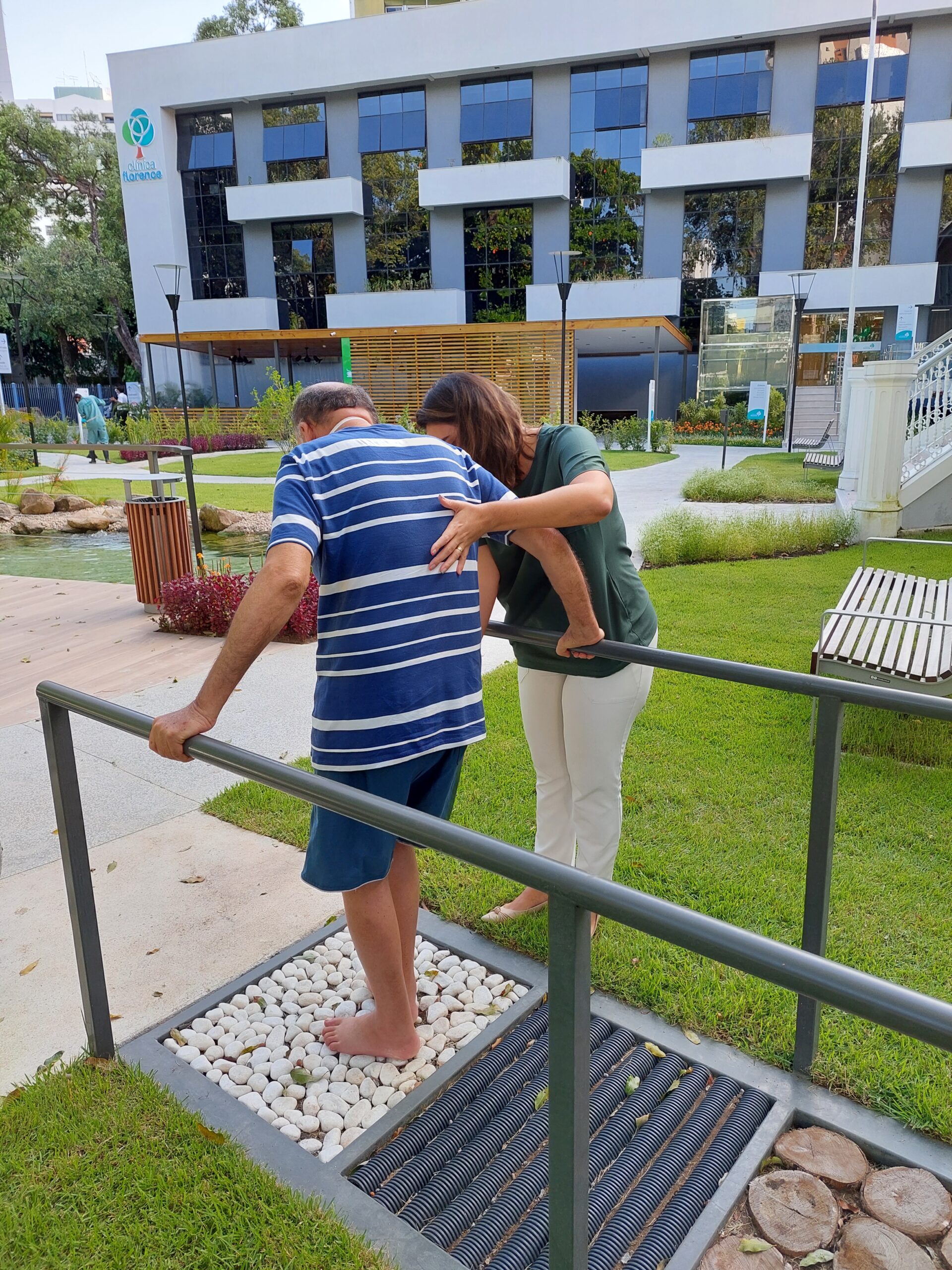 Sessão de reabilitação no jardim — cuidado que continua na transição para casa.